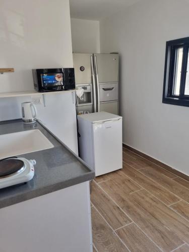 a kitchen with a refrigerator and a wooden floor at האשוח in Ashkelon