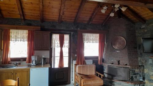 a kitchen with two windows and a chair and a sink at Guesthouse Sofia in Palaios Agios Athanasios