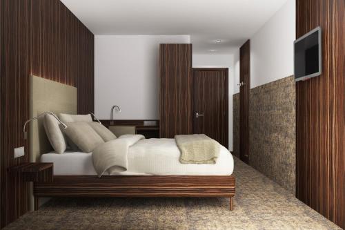 1 dormitorio con 1 cama y TV en la pared en MYHOTEL München Olching, en Olching