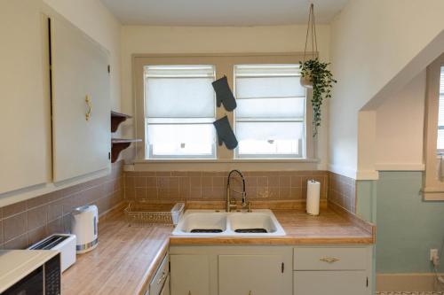 a kitchen with a sink and two windows at Historic Revival Midtown Memphis Duplex 64 Yes Pets Fast Wifi Free Parking in Memphis