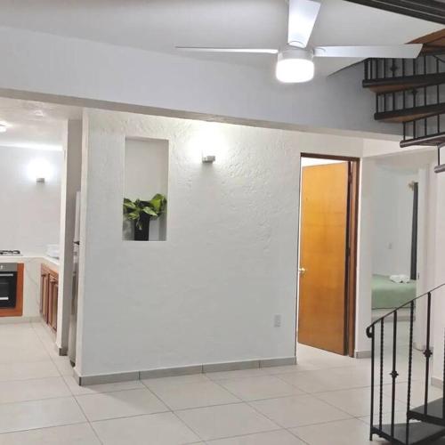 a room with a hallway with a door and a staircase at Casa Zihuana in Ixtapa