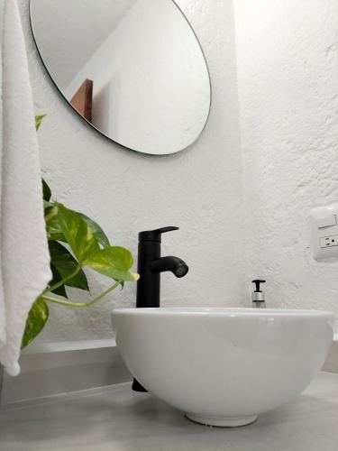 a bathroom with a white sink and a mirror at Casa Zihuana in Ixtapa
