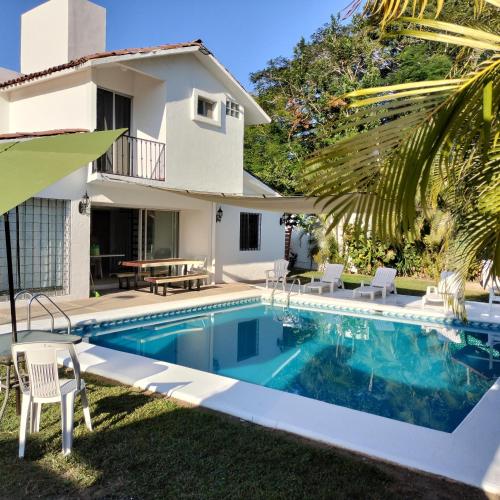 a villa with a swimming pool and a house at Casa Zihuana in Ixtapa