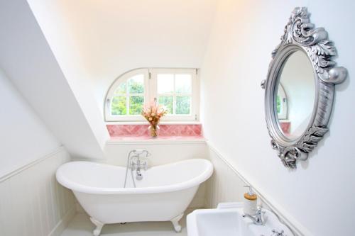 bagno bianco con lavandino e specchio di Hailey's Haven a Dungarvan
