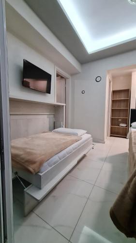 a bedroom with a bed and a tv on the wall at D&B Apartment 3 in Paralia Katerinis