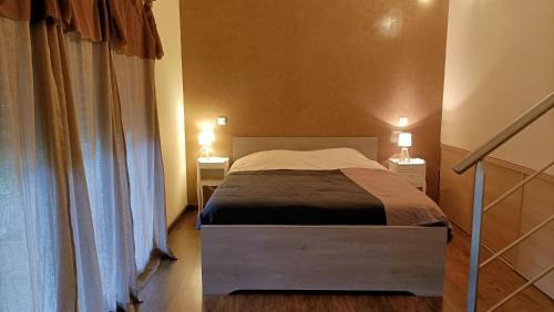ein Schlafzimmer mit einem Bett mit zwei Nachttischen und zwei Lampen in der Unterkunft Location Rez de maison dans quartier charmant in Saint-Raphaël