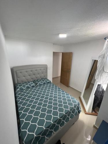 een kleine slaapkamer met een bed in een kamer bij Apto nuevo, amoblado sector tranquilo, buen precio in Barranquilla