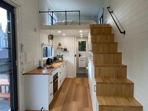 a kitchen with a staircase in a tiny house at Tiny House Clunes at The Old Butter Factory in Clunes