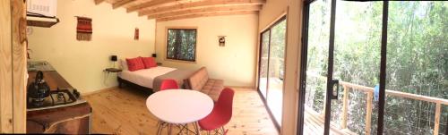 a room with a bed and a table and a balcony at Bosque Vivo in Recinto