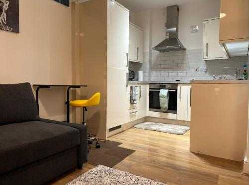 sala de estar con sofá y cocina en Modern and Stylish 1bed flat, en Barking