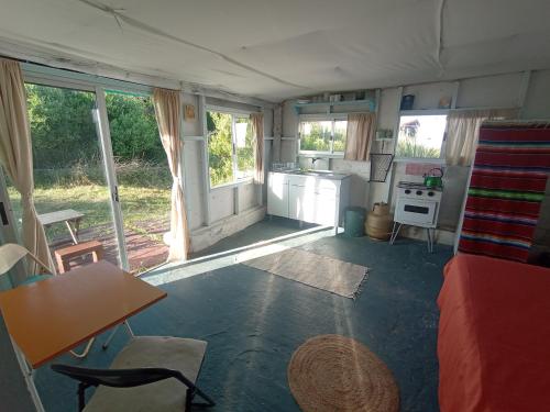 a living room with a couch and a table and a kitchen at Polonesa in Cabo Polonio