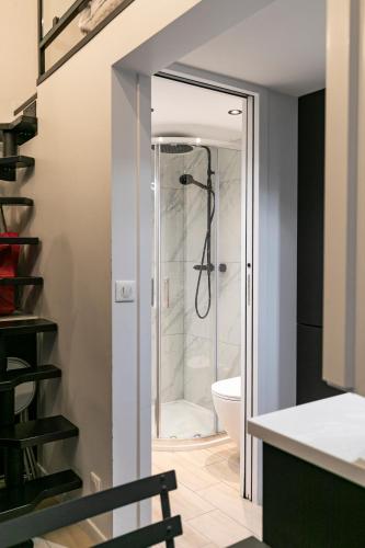 La salle de bains est pourvue d'une douche à l'italienne et de toilettes. dans l'établissement Le studio de belleville 2 à 4 personnes, à Paris