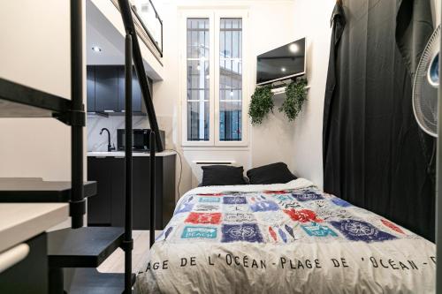 une petite chambre avec un lit et un lavabo dans l'établissement Le studio de belleville 2 à 4 personnes, à Paris