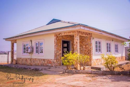 una pequeña casa blanca con una fachada de piedra en Dayspring Apartments. Entire house for guests. Ekiti, en Ado Ekiti