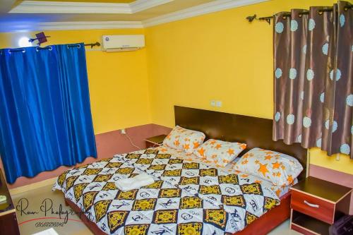 a bedroom with a bed and a blue curtain at Dayspring Apartments. Entire house for guests. Ekiti in Ado Ekiti