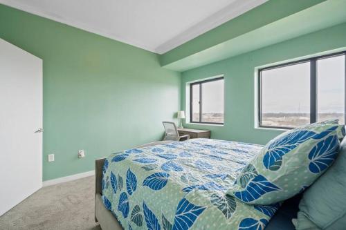 Cozy Condo @ Charlotte NC! w/Pool- Walk to Uptown في تشارلوت: غرفة نوم مع سرير والجدران الزرقاء والنوافذ