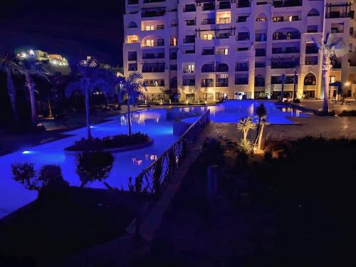 a swimming pool with blue lights in a building at Lovely studio Al-Dau Heights in Hurghada
