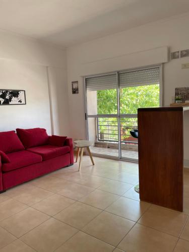 ein Wohnzimmer mit einem roten Sofa und einem Fenster in der Unterkunft Rio Tranquilo in Concepción del Uruguay