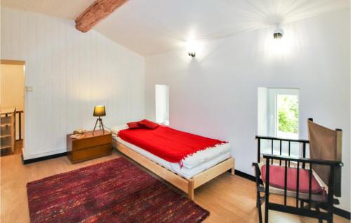 um quarto com uma cama vermelha e uma cadeira em Nice Home In Goult With Private Swimming Pool, Can Be Inside Or Outside em Goult