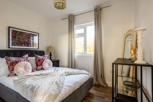 1 dormitorio con cama con almohadas y ventana en Stillness- Connect to the Nature in the Hot Tub en Blandford Forum