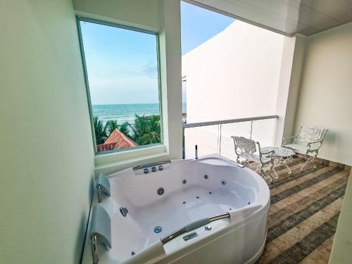 a bath tub in a room with a large window at Hotel Boutique El Mirador in Arboletes