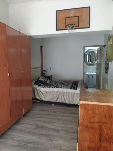 1 dormitorio con 1 cama y un aro de baloncesto en la pared en Cómodo break and breakfast en Godoy Cruz, Mendoza en Godoy Cruz