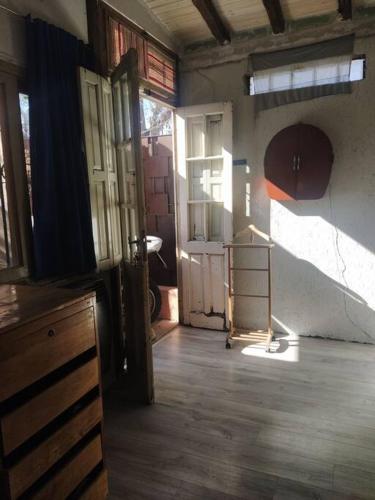 una habitación vacía con puertas y una habitación con suelo de madera en Cómodo break and breakfast en Godoy Cruz, Mendoza en Godoy Cruz