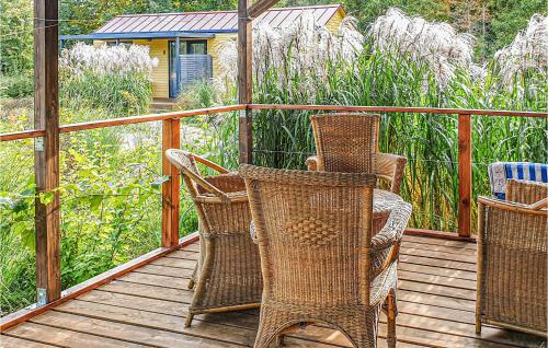 three wicker chairs sitting on a wooden deck at Pet Friendly Home In Biskupiec With Lake View in Biskupiec