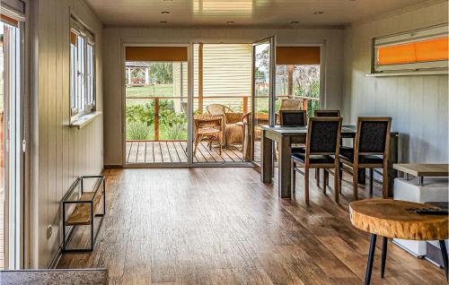a dining room with a table and chairs and a porch at Pet Friendly Home In Biskupiec With Lake View in Biskupiec