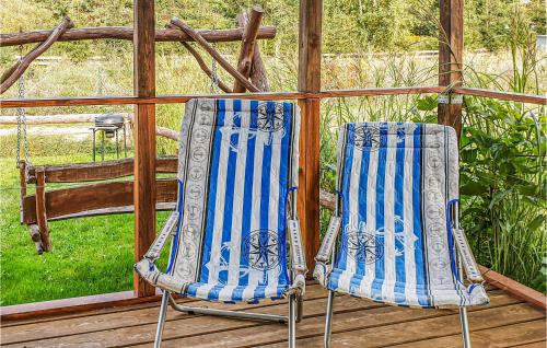 two chairs sitting on a wooden deck at Pet Friendly Home In Biskupiec With Lake View in Biskupiec