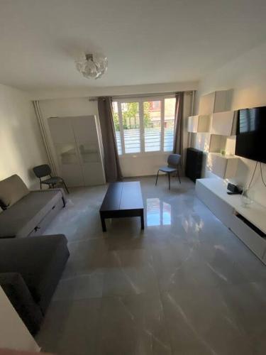 sala de estar con sofá y mesa en Superbe appartement Vanves T3 avec parking en Vanves