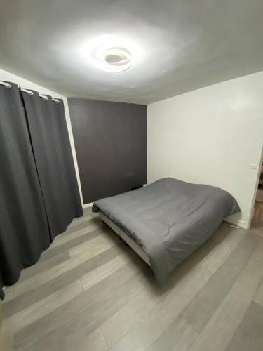 - une chambre avec un lit et des rideaux dans l'établissement Superbe appartement Vanves T3 avec parking, à Vanves
