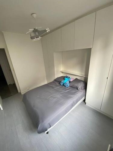 un osito de peluche sentado en una cama en una habitación en Superbe appartement Vanves T3 avec parking en Vanves