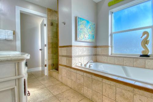 a bathroom with a tub and a window at On The Rocks 2 in Clearwater Beach