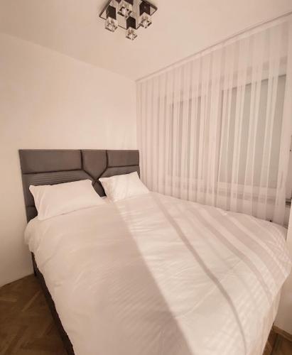 ein Schlafzimmer mit einem großen Bett mit weißer Bettwäsche in der Unterkunft Diamond Apartment Prishtina 2 in Pristina