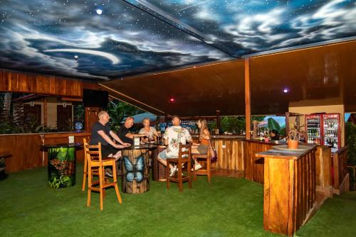 a group of people sitting at a bar with a sky ceiling at Ara Ambigua Lodge in Sarapiquí