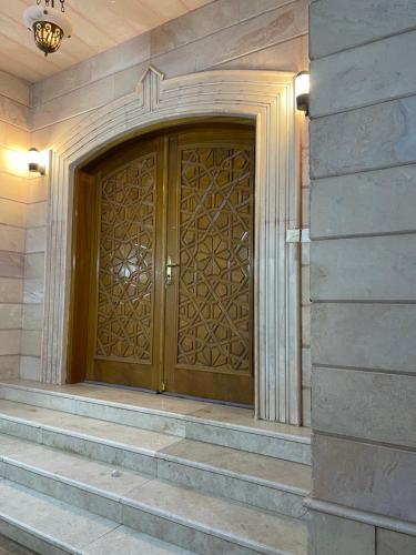 a large wooden door in a building with stairs at فيلا سلطانة in Medina