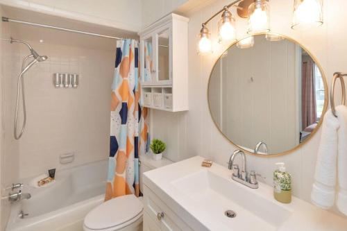 a bathroom with a sink toilet and a mirror at Stylish 3 bedroom home close to downtown Mobile in Mobile