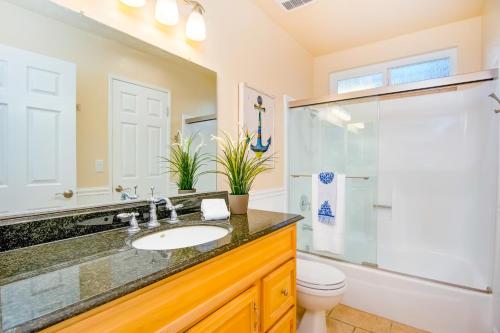 Un baño con lavabo, ducha e inodoro. en North Beach E, en San Clemente