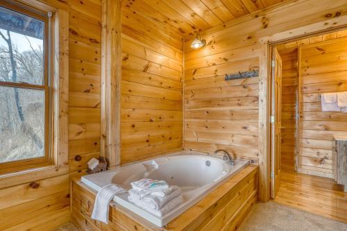uma casa de banho em madeira com uma banheira e uma janela em Do Not Disturb em Gatlinburg