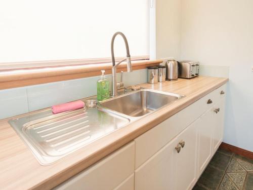 a kitchen counter with a stainless steel sink at Agincourt in Invergordon