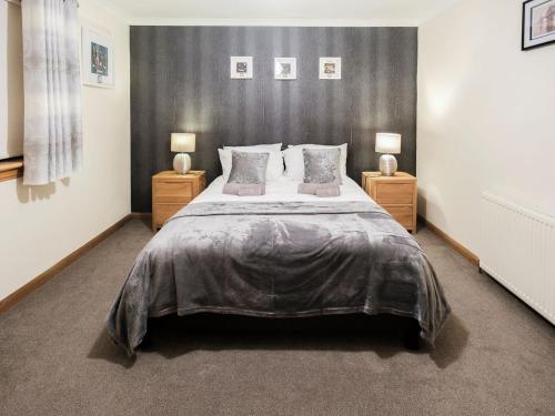 a bedroom with a large bed with two night stands at Agincourt in Invergordon