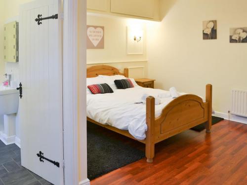 um quarto com uma cama com lençóis brancos e almofadas em Stable Cottage - Uk3285 em Guyzance