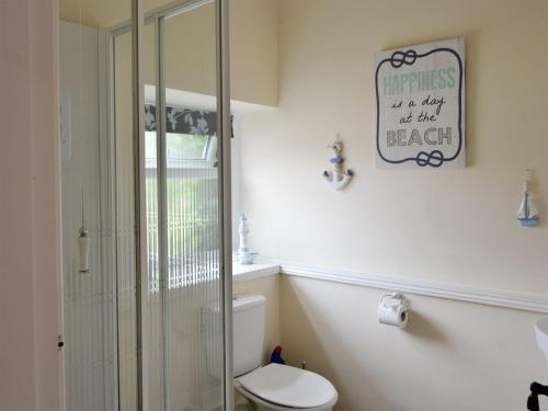 a bathroom with a toilet and a glass shower at Stable Cottage - Uk3285 in Guyzance