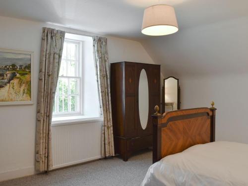 a bedroom with a bed and a window at The Courtyard Suite in Oathlaw