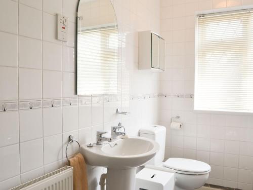 a white bathroom with a sink and a toilet at Jackdaw House in Bridlington