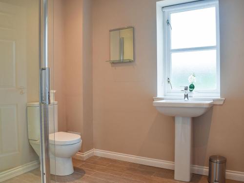 łazienka z toaletą, umywalką i oknem w obiekcie Craigmore View-uk34220 w mieście Aberfoyle
