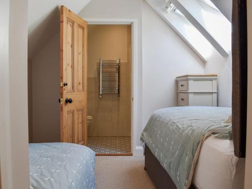 a bedroom with a bed and a door to a bathroom at Speedwell Cottage in Woodgreen