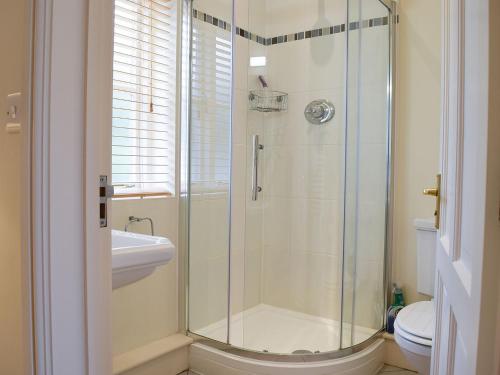een badkamer met een douche, een wastafel en een toilet bij Len Cottage in Thurning