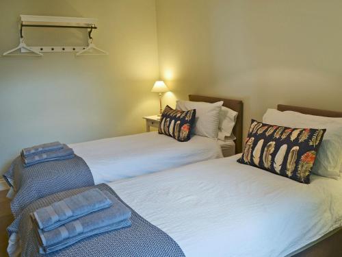 two beds sitting next to each other in a room at Havannah Cottage in Alnham